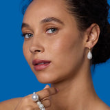Front view of 18K WG YG Earrings on model, against a blue background.