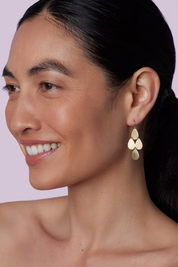 Front view of flat gold 18K YG 4 Drop Earrings on model, against a pink background.