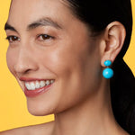 Front view of Gumball 18K YG Earrings on model, against a yellow background.