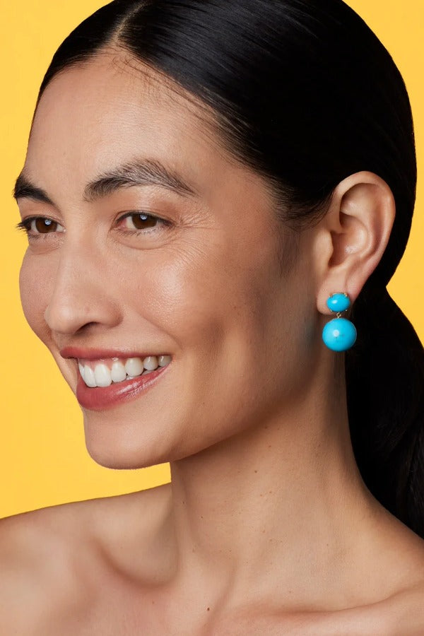 Front view of Gumball 18K YG Earrings on model, against a yellow background.