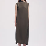 Front view of khaki soft fold pleats dress on model wearing black loafers, against a white background.