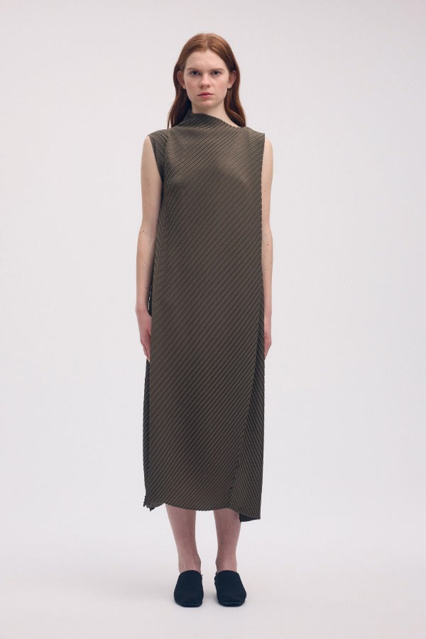 Front view of khaki soft fold pleats dress on model wearing black loafers, against a white background.