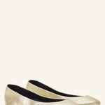 Pair view of gold ballerina flats on white background, with no model shown.