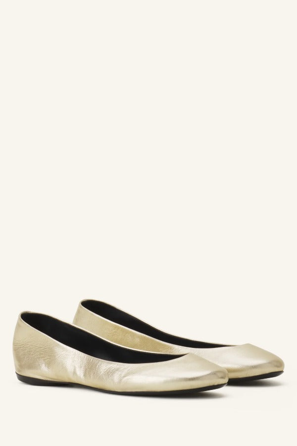 Pair view of gold ballerina flats on white background, with no model shown.