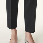 Front and side view of silver ballerina flats on model wearing black pants, against a white background.