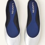 Overhead view of silver ballerina flats on white background, with no model shown.