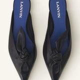 Overhead view of black flat mule bow on white background, with no model shown.