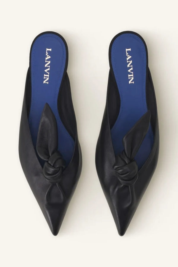 Overhead view of black flat mule bow on white background, with no model shown.