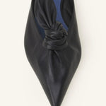 Overhead closeup of black flat mule bow on white background, with no model shown.