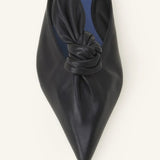 Overhead closeup of black flat mule bow on white background, with no model shown.