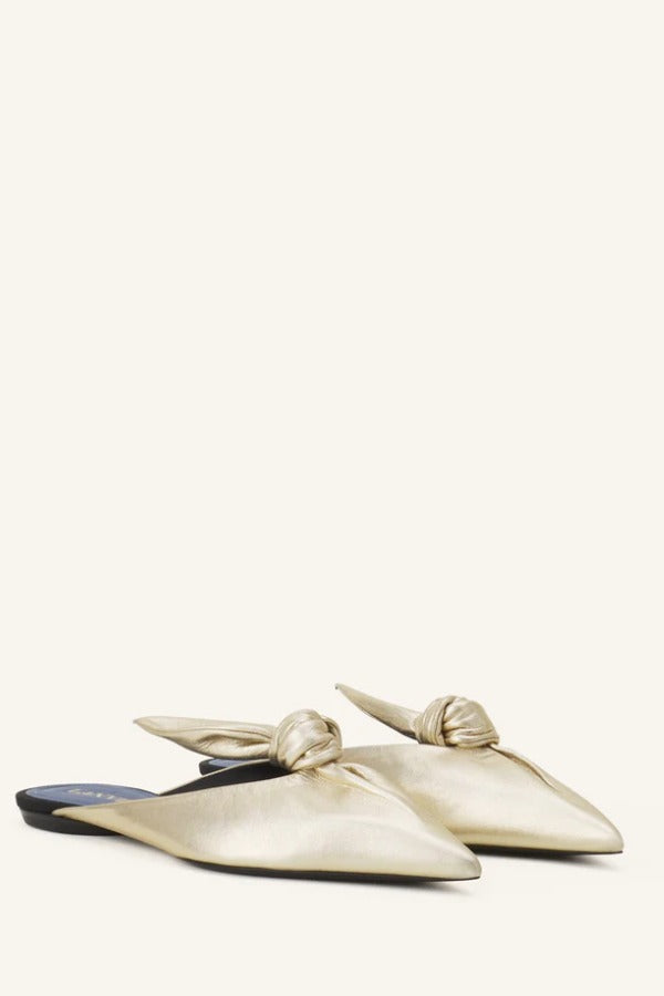 Pair View of gold flat mule bow on white background, with no model shown.