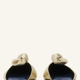 Back view of gold flat mule bow on white background, with no model shown.