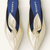 Overhead view of gold flat mule bow on white background, with no model shown.