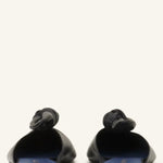 Back view of black flat mule bow on white background, with no model shown.