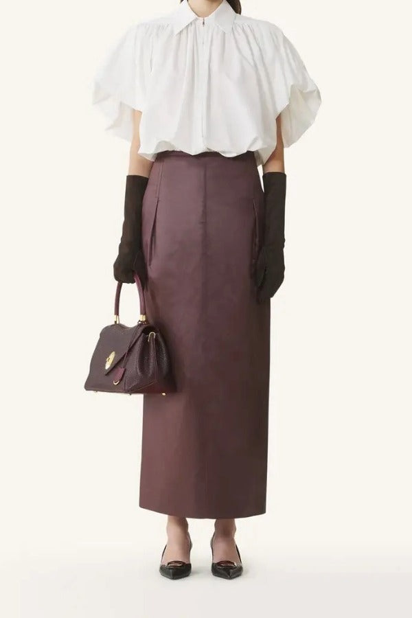 Front view of cloth puffy sleeves top on model wearing burgundy skirt and heels, against a white background.