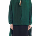 Front view of malachite scarf blouse on model wearing black skirt, against a white backgorund.