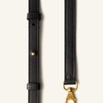 Strap view of black tote bag on white background, with no model shown.