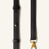 Strap view of black tote bag on white background, with no model shown.