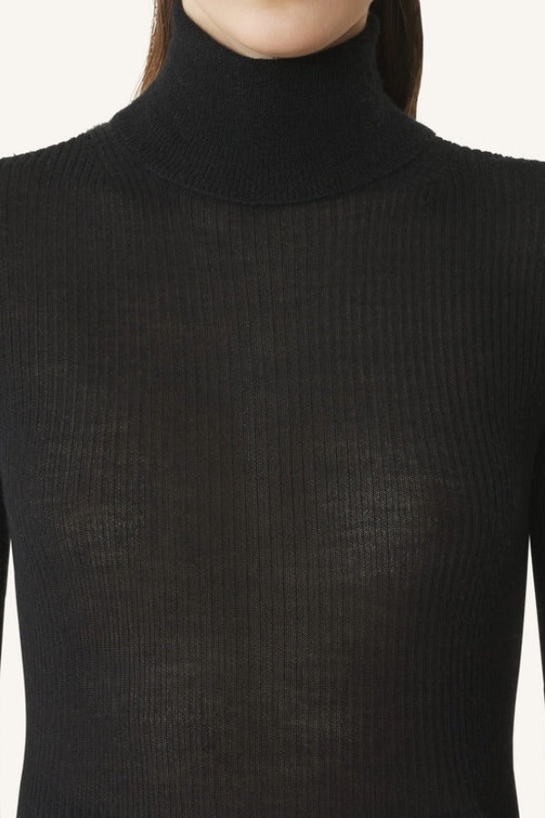 Front closeup view of black turtleneck jumper on model, against a white background.