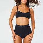 Front view of black genevieve bikini bottom on brown-haired model, against a white background.