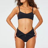 Front view of black genevieve bikini botton zippd down on brown-haired model, against a white background.