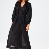 Front view of black maxi poet dress on brown-haired model wearing brown sandals, against a white background.