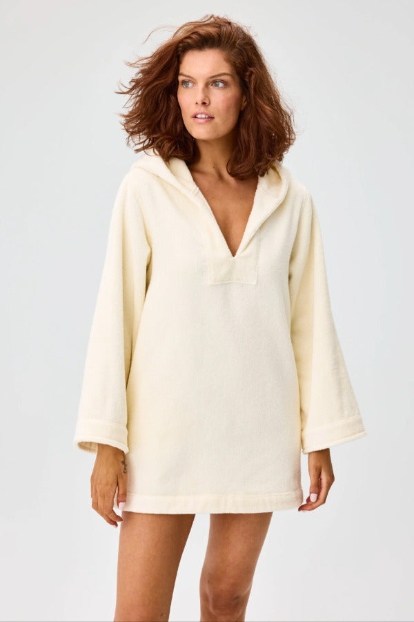 Front view of cream terry beach tunic on brown-haired model, against a white background.