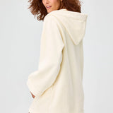 Back view of cream terry beach tunic on brown-haired model against a white background.