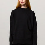 Front view of nero amelia rn sweater on model wearing black pants, against a white background.