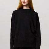 Front view of nero amelia rn sweater on model wearing black pants, against a white background.