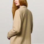Back view of naturale beatrix db jacket on model wearing naturale skirt, against a white background.