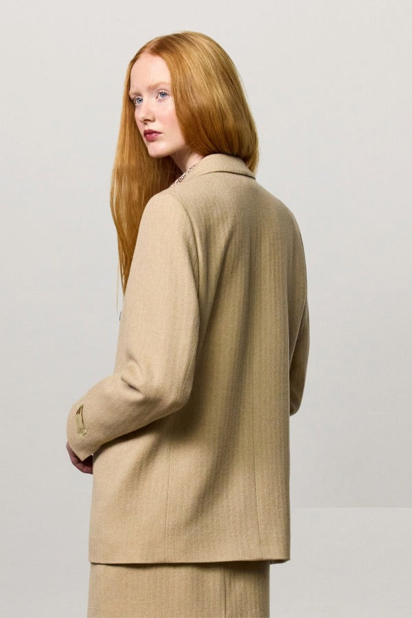 Back view of naturale beatrix db jacket on model wearing naturale skirt, against a white background.