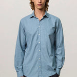 Front view of blue rain canary shirt on model wearing black trousers, against a white background.