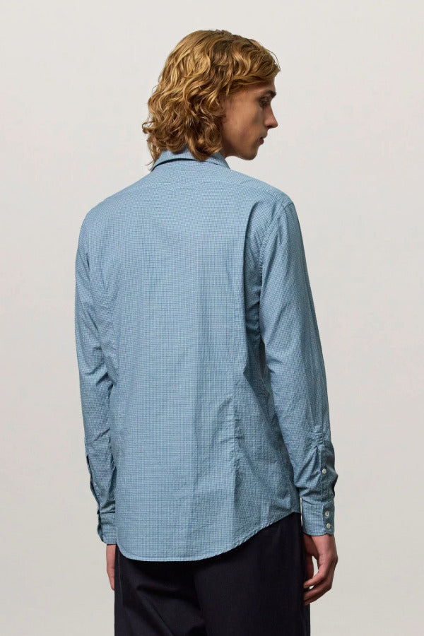 Back view of blue rain canary shirt on model wearing back trousers, against a white background.