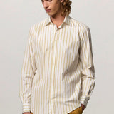 Front view of saffron genova classic shirt on model wearing saffron trousers, against a white background.