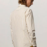 Back view of saffron genova classic shirt on model wearing saffron trousers, against a white background.