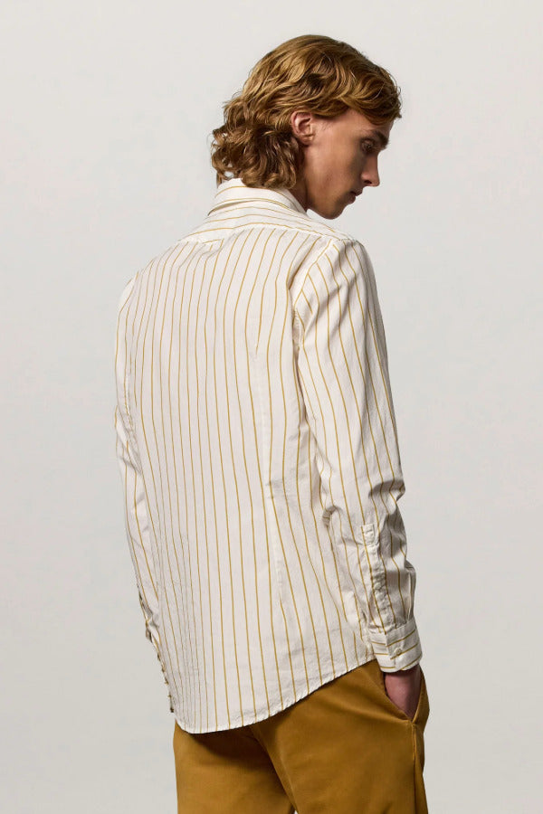 Back view of saffron genova classic shirt on model wearing saffron trousers, against a white background.