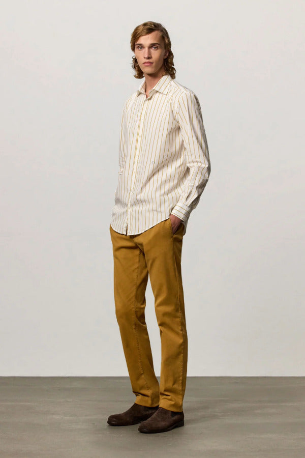 Front slanted view of saffron genova classic shirt on model wearing saffron trousers and brown suede shoes, against a white background.