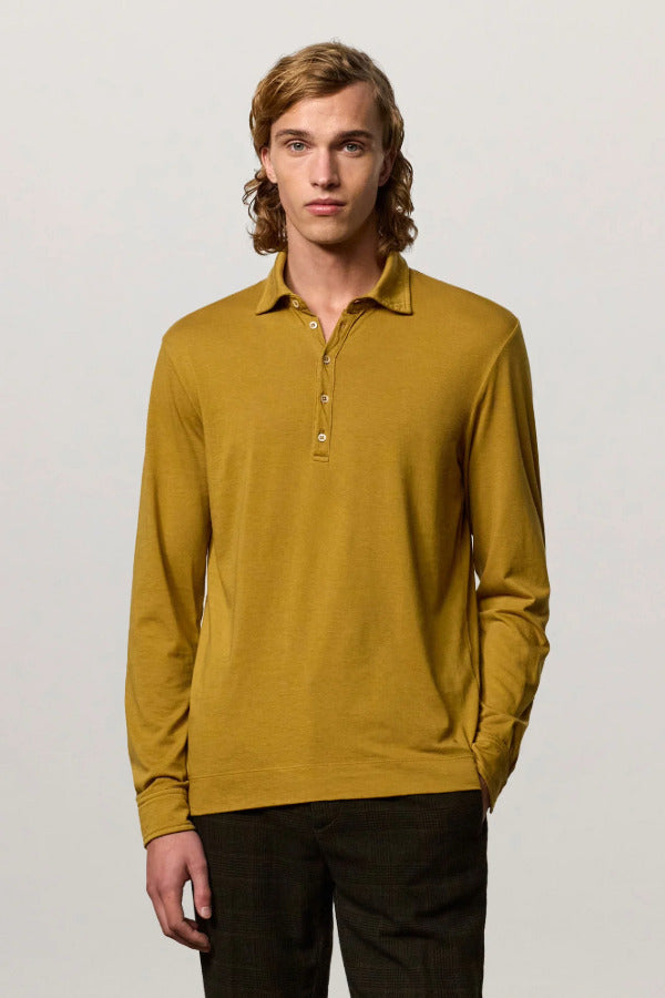 Front view of saffron ischia ls polo shirt on model wearing brown tweed trousers, against a white background.