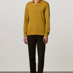 Front view of saffron ischia ls polo shirt on model wearing brown tweed trousers and brown suede shoes, against a white background.