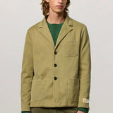 Front view of verde baglietto blazer on model wearing green sweater underneath and green corduroys, against a white background.