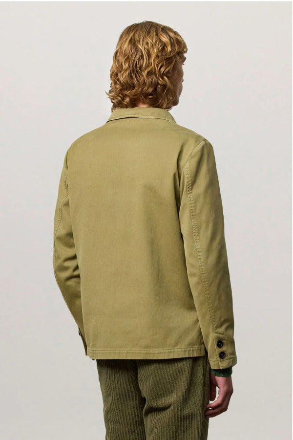 Back view of verde baglietto blazer on model wearing green corduroys, against a white background.
