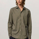 Front view of verde genova classic shirt on model wearing black trousers, against a white background.