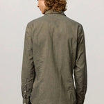 Back view of verde genova classic shirt on  model wearing black trousers, against a white background.