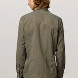 Back view of verde genova classic shirt on  model wearing black trousers, against a white background.
