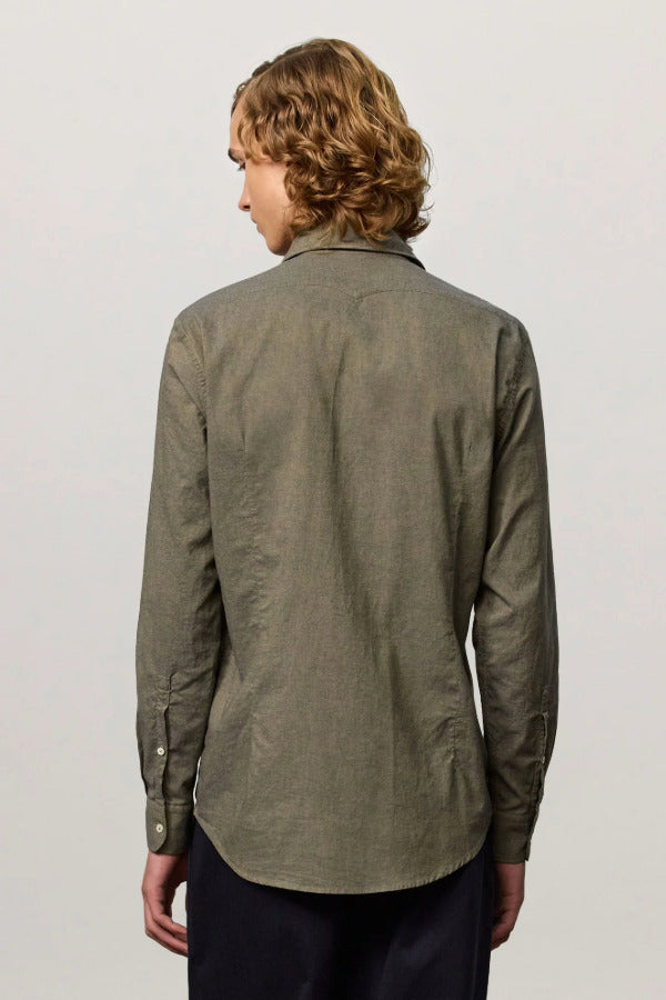 Back view of verde genova classic shirt on  model wearing black trousers, against a white background.
