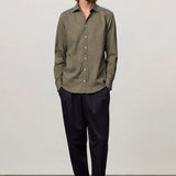 Front view of verde genova classic shirt on model wearing black trousers and brown suede shoes, against a white background.