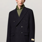Front view of blue brando db blazer on model wearing green t-shirt and yellow pants, against a white background.