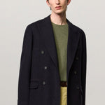 Alternate front view of blue brando db blazer on model wearing green t-shirt and yellow pants, against a white background.