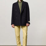 Front view of blue brando db blazer on model wearing green t-shirt, yellow pants and boots, against a white background.